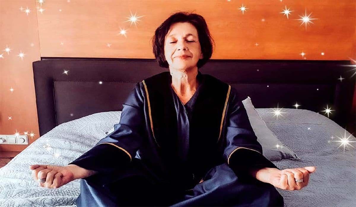 Trouwambtenaar Sandy zit op bed te mediteren.