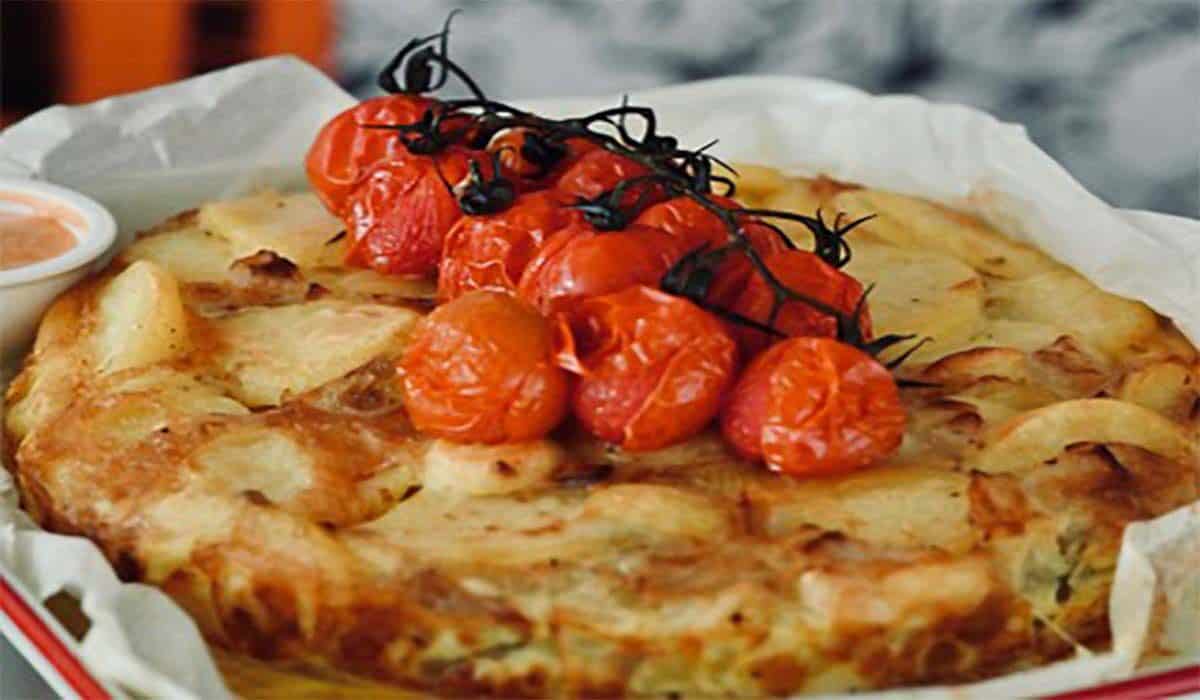 Close-up van Spaanse Tortilla met tomaatjes uit de oven