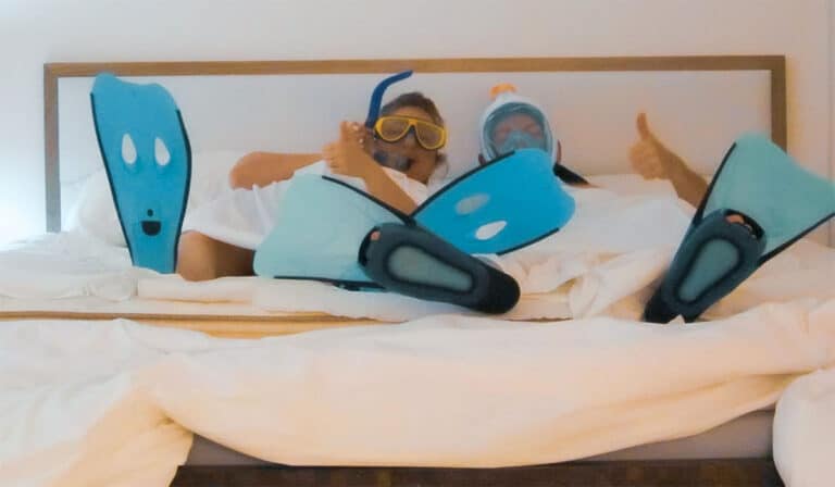 Echtpaar met snorkels op in bed ter illustratie van rubriek ‘Mijn meest bizarre vakantie ooit.’
