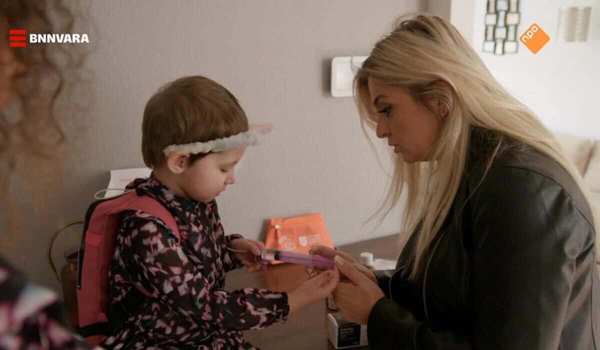 Bobbi Eden helpt Allexa, het dochtertje van Jaylin, met haar medicatie in het televisieprogramma vier handen op een buik.