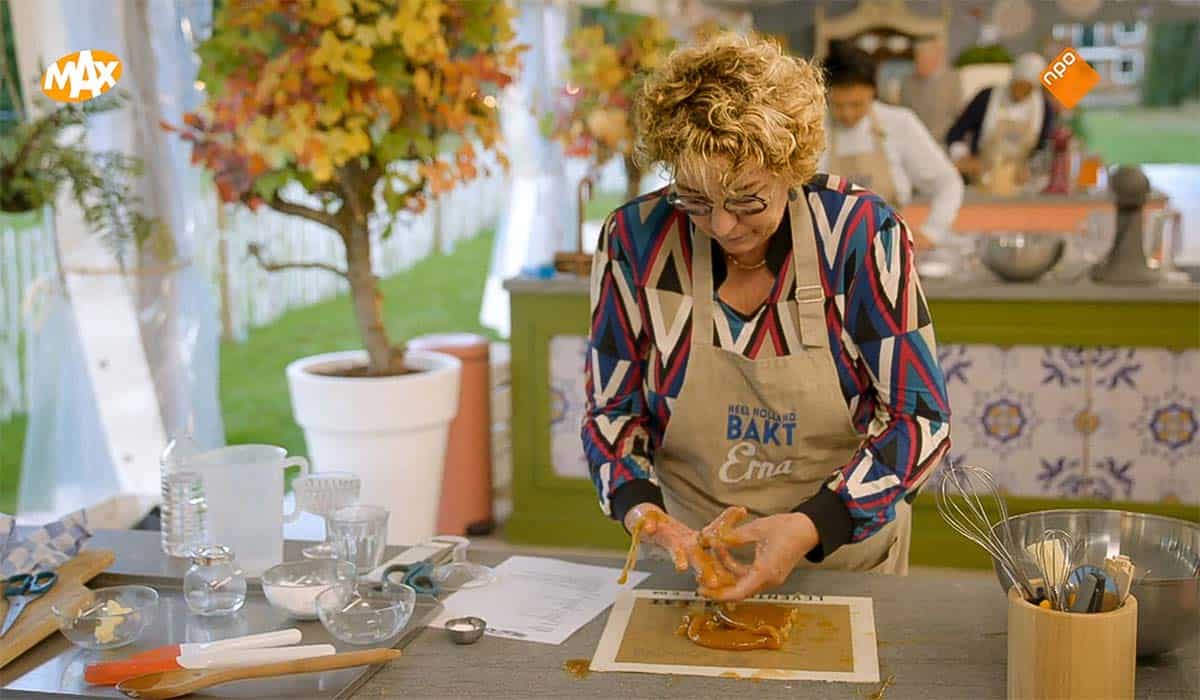 Heel Holland Bakt 2023 deelneemster Erna zit met haar handen onder de karamel.