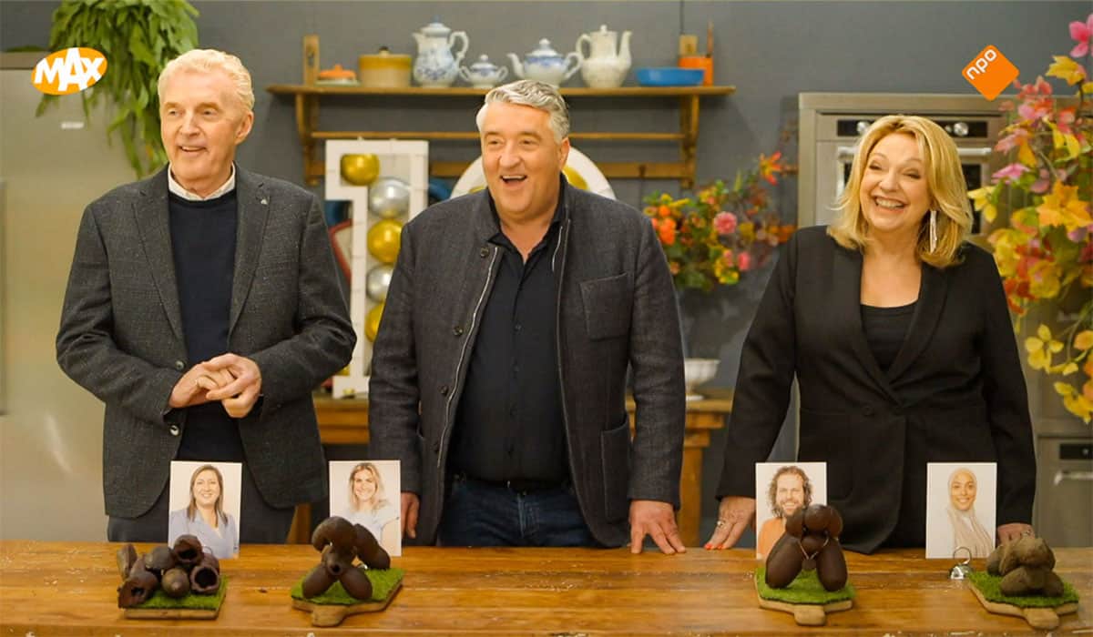Twee mannen en een vrouw staan achter tafel met foto’s chocolade. Screenshot uit televisieprogramma Heel Holland Bakt.