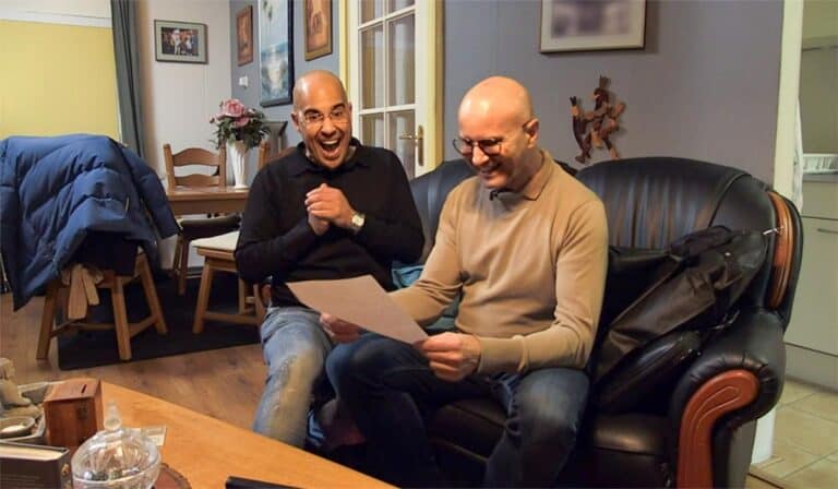 Foto gemaakt tijdens opnames televisieprogramma’s Steenrijk Straatarm waar te zien is hoe twee mannen op een bank zitten en een brief lezen. Credits: Still SBS6