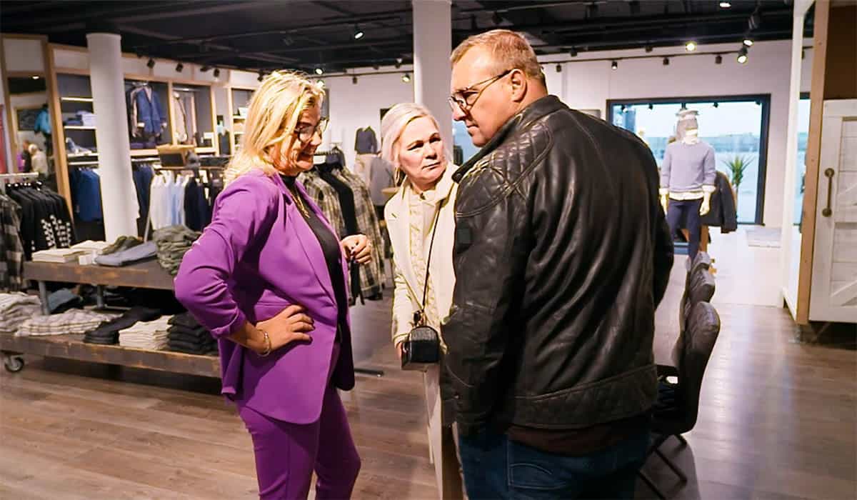 Derrekien en Tony praten met de verkoopster in een kledingwinkel tijdens de opnames van de serie Urk.