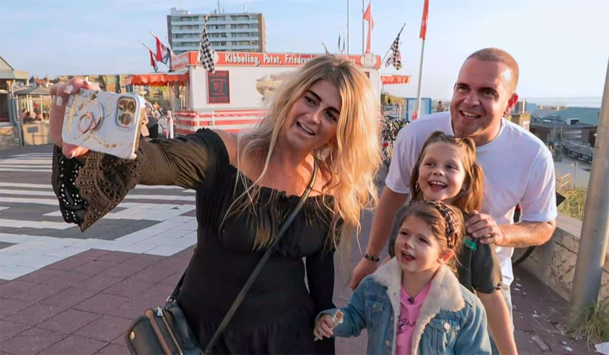 Steenrijk Straatarm deelnemers en YouTubers De Hollies filmen zichzelf met een mobiele telefoon op een boulevard. Moeder Natasja, vader Mike en twee kleine meisjes.