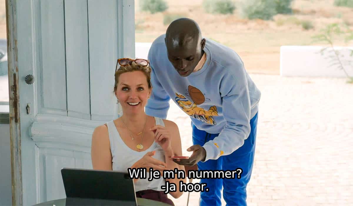 Leoni ter Braak zit achter een laptop terwijl een man haar telefoonnummer vraagt tijdens de opnames van Het Perfecte Plaatje op Reis 2023.
