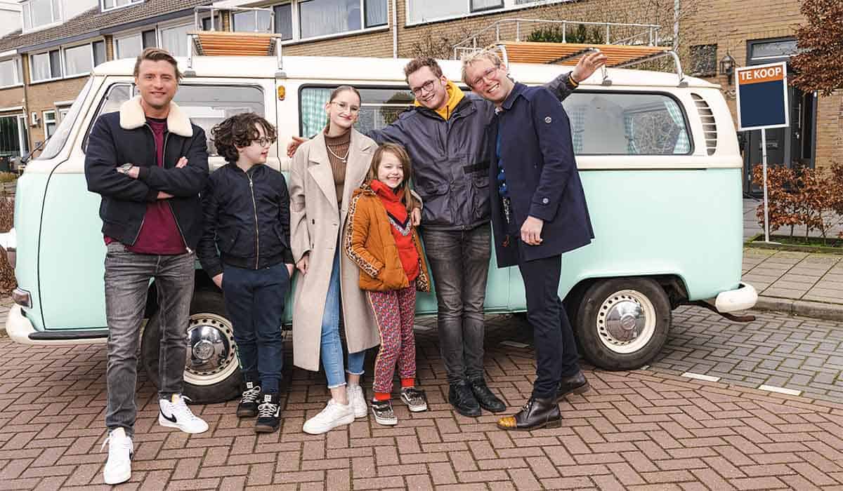 Jan Verrsteegh, makelaar Geert Klaver en de kinderen die meedoen als deelnemers van Kinderen Kopen Een Huis poseren voor een busje.