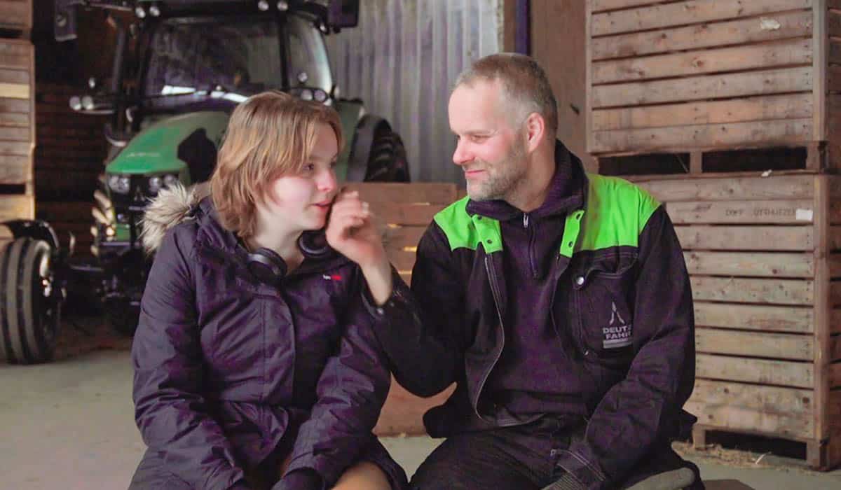 Boer en boerenzoon zijn in gesprek in stal in het RTL5 tv-programma Bij ons op de Boerderij
