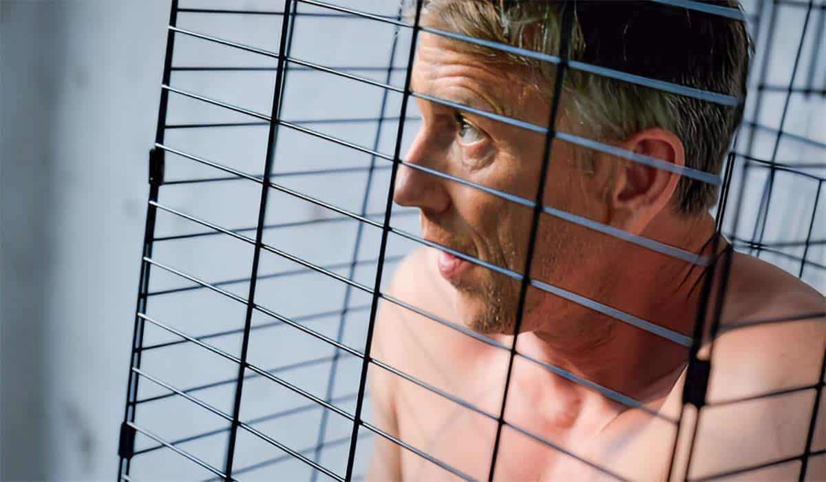 Waldemar Torenstra poseert tijdens een fotoshoot van Het Perfecte Plaatje 2023 in een kooi.