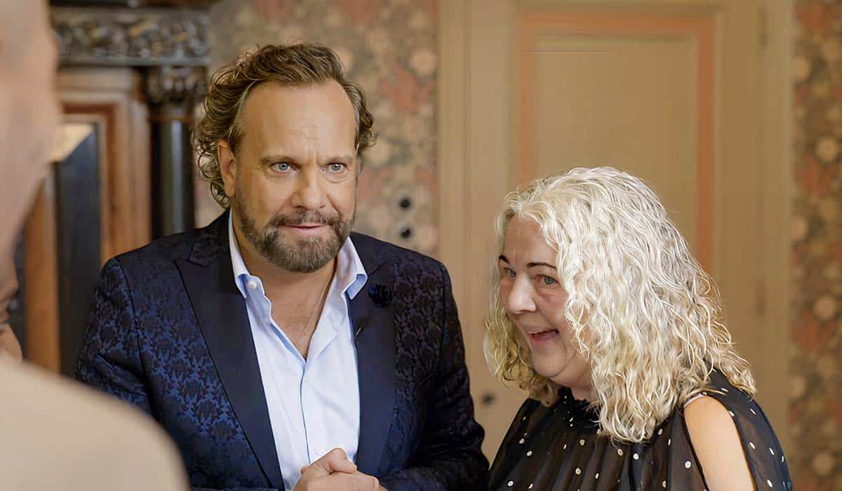 Sisca, de moeder van MAFS 2024 Marlou Bronswijk uit Epe, staat naast presentator Carlo Boshard in aflevering 1 van Married at First Sight seizoen 9
