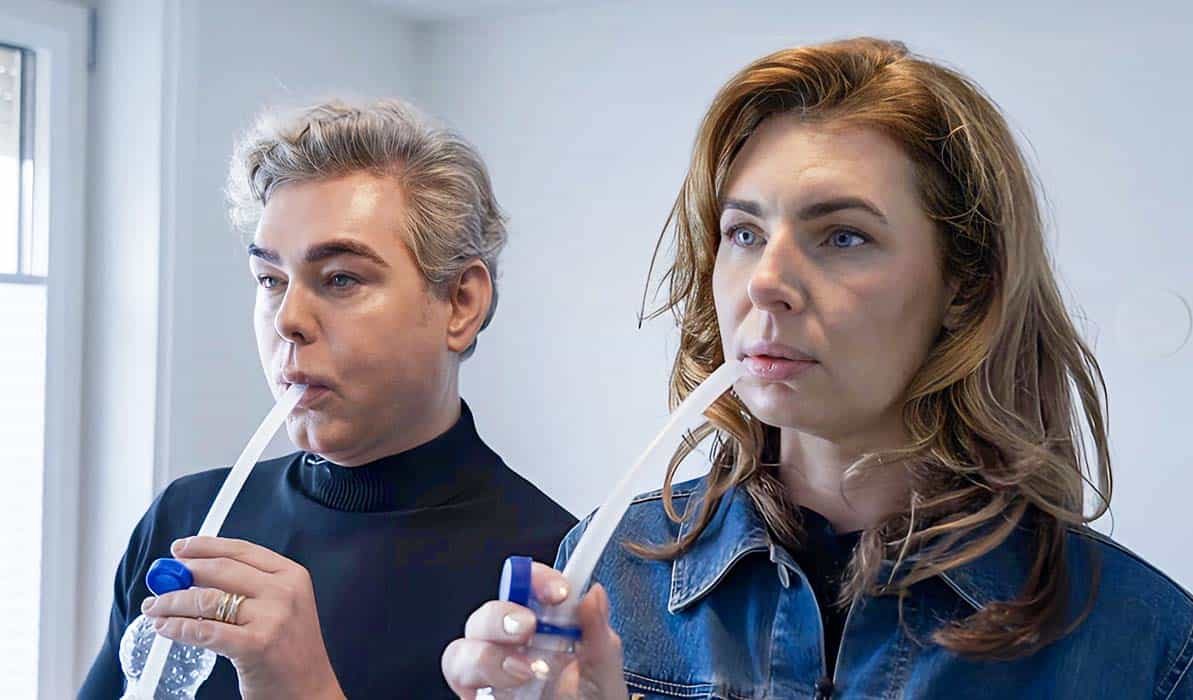 Teun Föhn en Greetje Hakvoort met een rietje in hun mond in de serie Urk
